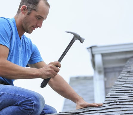 Ben Ross Roofing | Rock Hill, South Carolina | Man on roof with hammer nailing down shingle